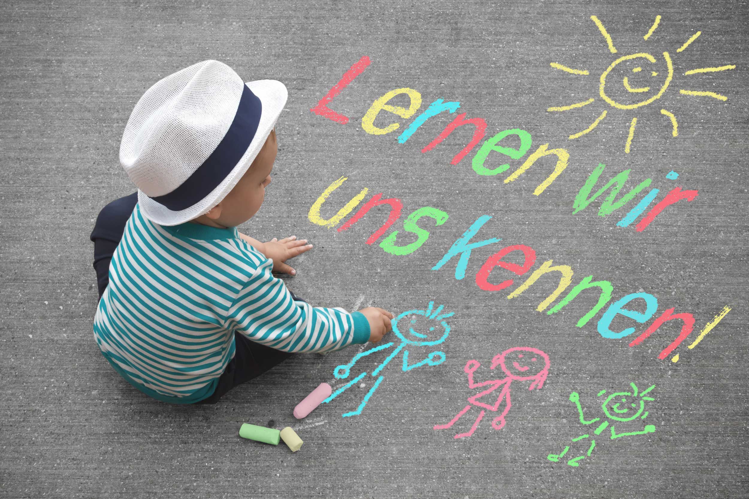 Ein Kind malt mit Kreide auf Asphalt, daneben steht bunt geschrieben: „Lernen wir uns kennen!“